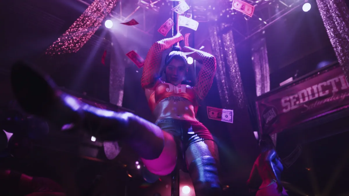 Pole dancer performing under dramatic lights with dollar bills flying during Seductive Saturdays in Vice City's nightclub in GTA 6 Trailer 2